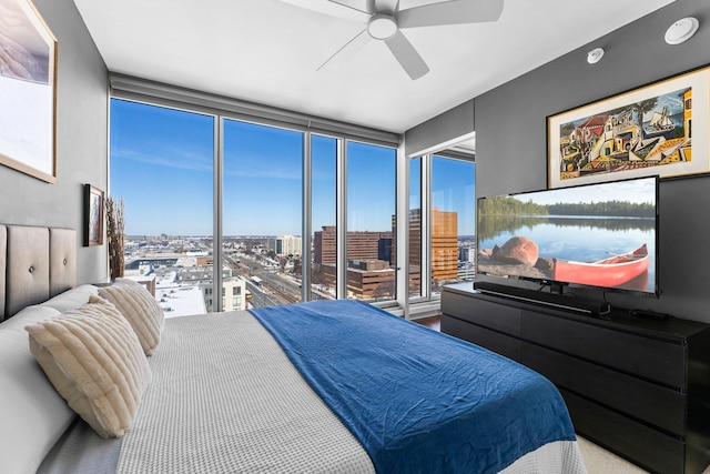 bedroom with a wall of windows and a ceiling fan