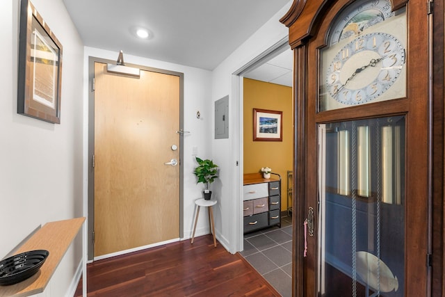 foyer entrance with electric panel, dark wood-style floors, and baseboards