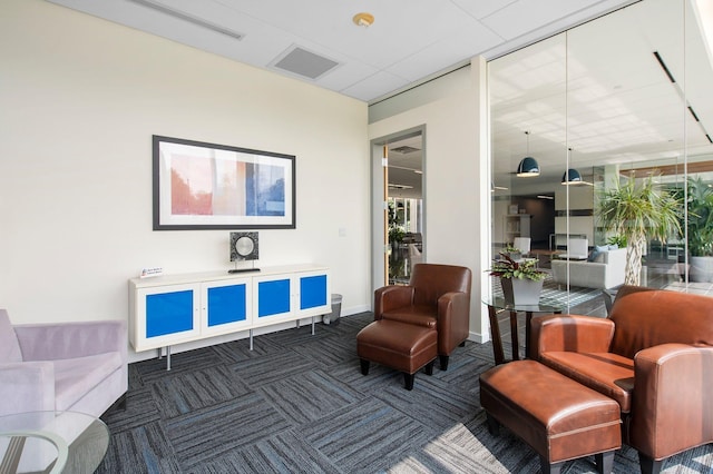 living area with baseboards, visible vents, and carpet floors