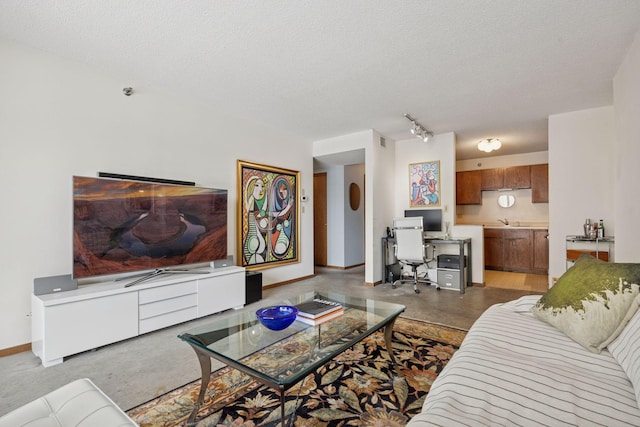 living area with rail lighting, baseboards, and a textured ceiling