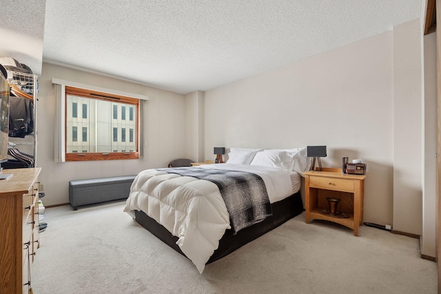 bedroom with a textured ceiling, carpet, and baseboards