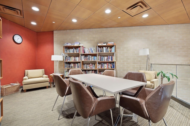 office featuring carpet floors, brick wall, visible vents, and recessed lighting