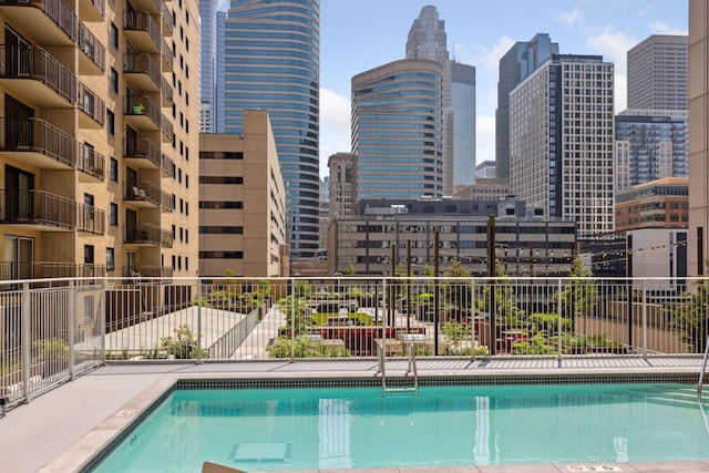 community pool featuring fence and a city view