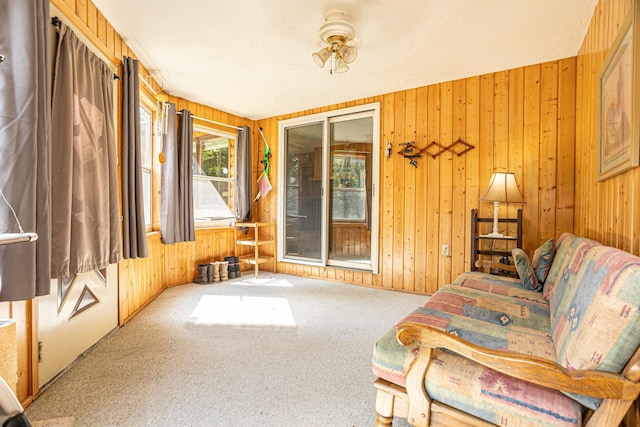 sitting room with carpet floors and wood walls