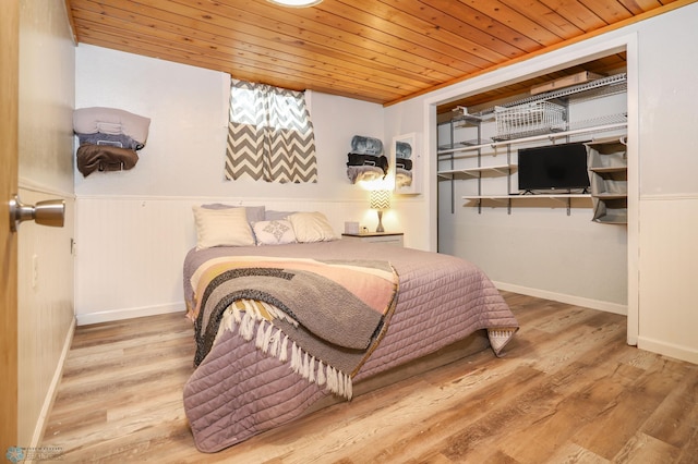 bedroom featuring wood ceiling, wainscoting, and wood finished floors