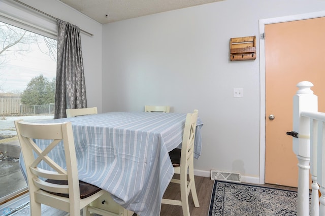 dining area with baseboards, visible vents, and wood finished floors