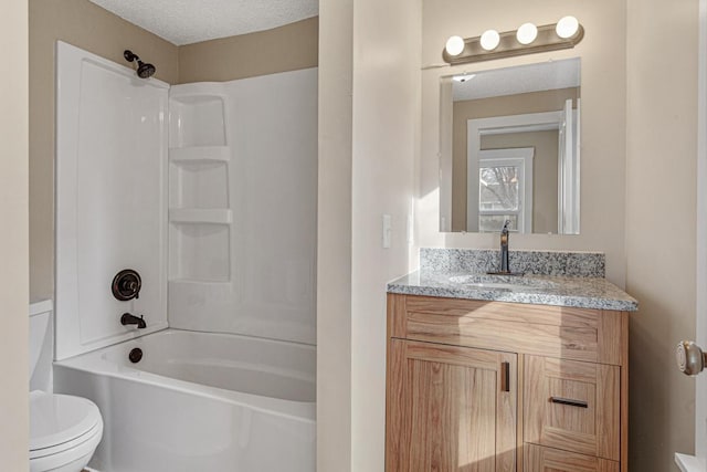 bathroom featuring a textured ceiling,  shower combination, vanity, and toilet