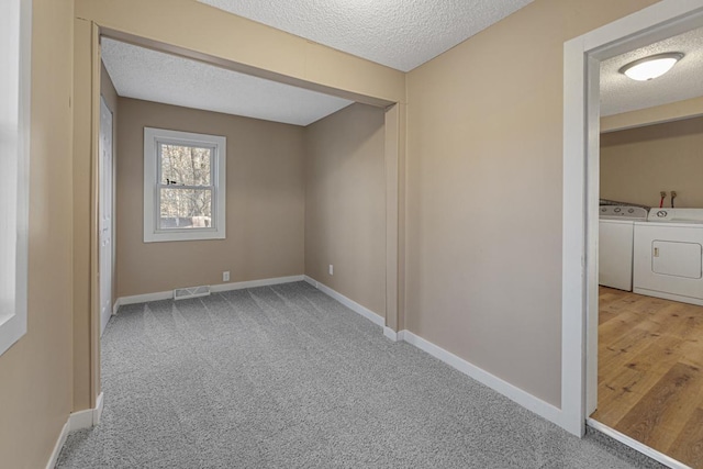 spare room featuring visible vents, a textured ceiling, and washing machine and clothes dryer