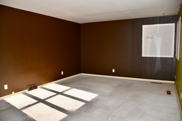 carpeted empty room with visible vents and baseboards