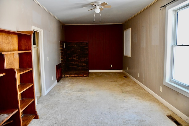 unfurnished living room with a wealth of natural light, ornamental molding, carpet flooring, and visible vents