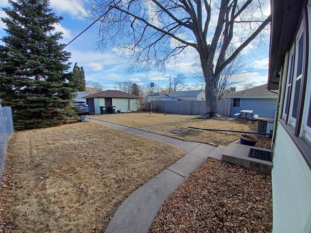 view of yard featuring an outdoor structure and fence