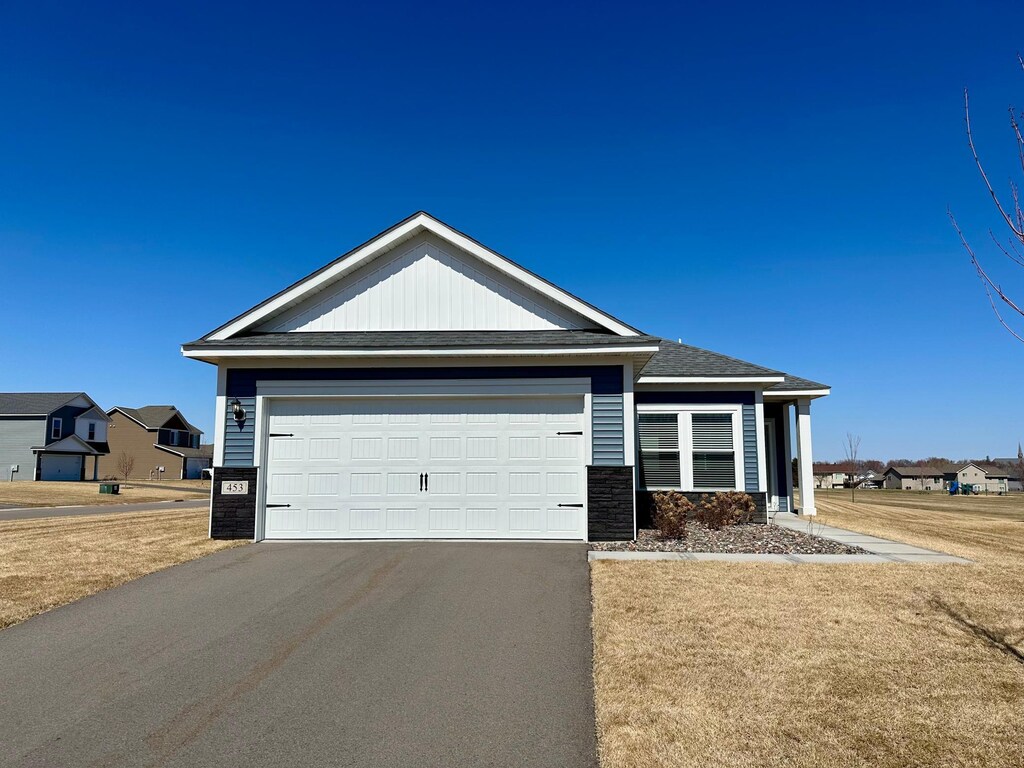 453 Wildflower Ln, Waverly, MN 55390 - ranch-style home featuring stone siding, a garage, aphalt driveway, and a front lawn