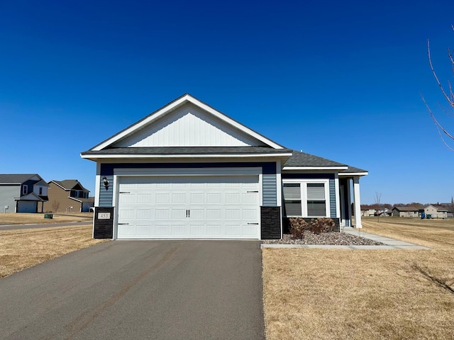453 Wildflower Ln, Waverly, MN 55390 - ranch-style home featuring stone siding, a garage, aphalt driveway, and a front lawn