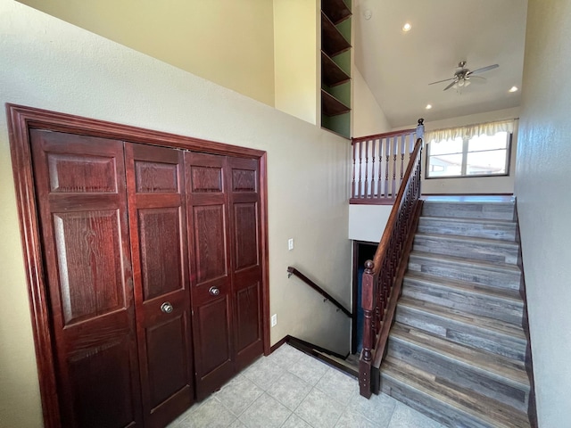 stairs with a ceiling fan, lofted ceiling, baseboards, and recessed lighting