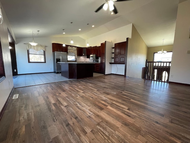 kitchen with a center island, dark wood finished floors, stainless steel appliances, open floor plan, and ceiling fan with notable chandelier