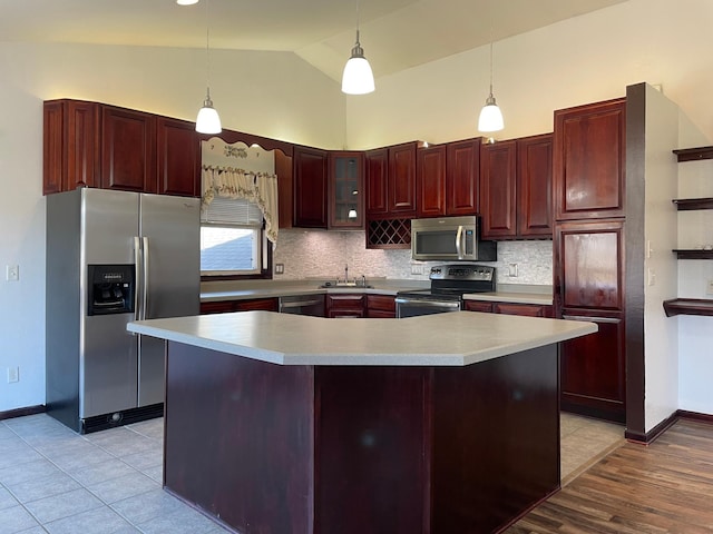 kitchen with dark brown cabinets, appliances with stainless steel finishes, a sink, and decorative backsplash