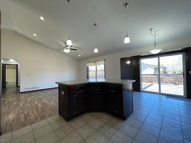 kitchen with light countertops, visible vents, arched walkways, and light tile patterned floors