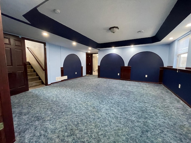 cinema room with carpet floors, a tray ceiling, visible vents, and recessed lighting