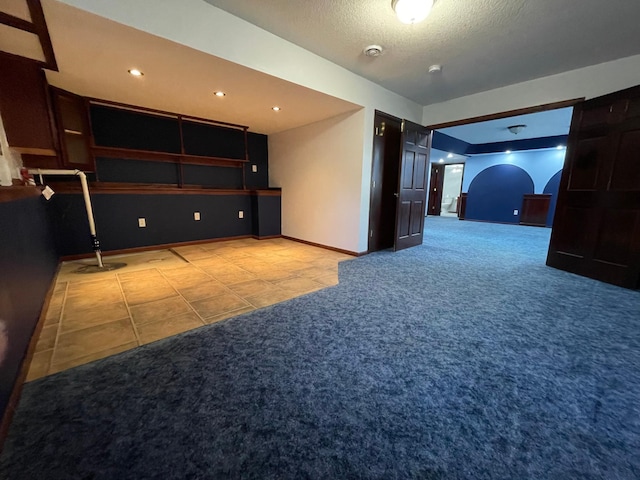 tiled empty room with carpet floors, baseboards, a textured ceiling, and recessed lighting