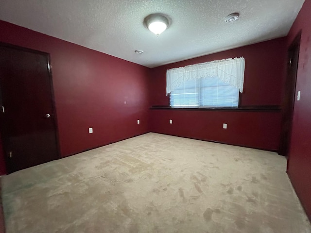 unfurnished bedroom featuring a textured ceiling and carpet