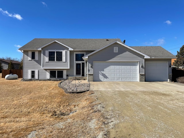 view of front of home featuring a garage, driveway, and roof with shingles