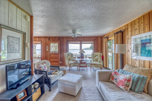 living room with light carpet, plenty of natural light, and wooden walls