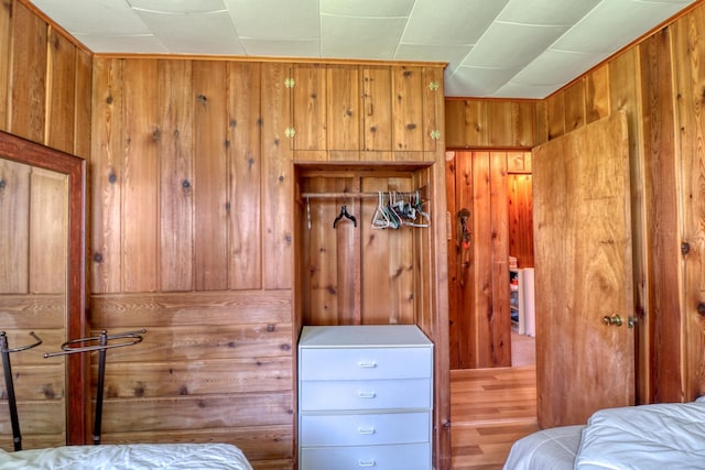 bedroom featuring wood walls and wood finished floors