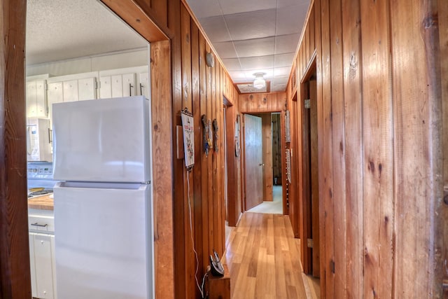 hallway featuring wood walls and light wood finished floors