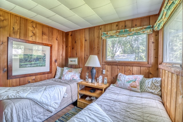 bedroom featuring wood finished floors and wooden walls