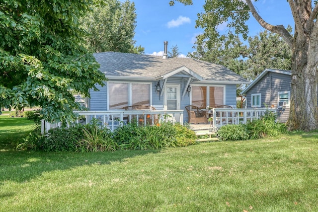 view of front of house with a front lawn and roof with shingles