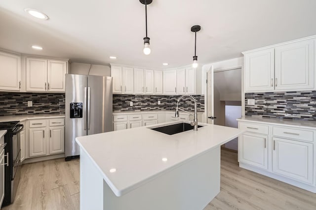 kitchen with light wood-style flooring, black gas range oven, white cabinets, a sink, and stainless steel fridge with ice dispenser