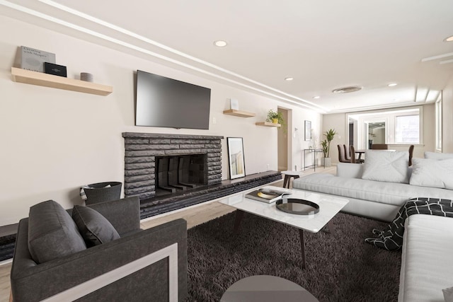 living room featuring recessed lighting and a stone fireplace