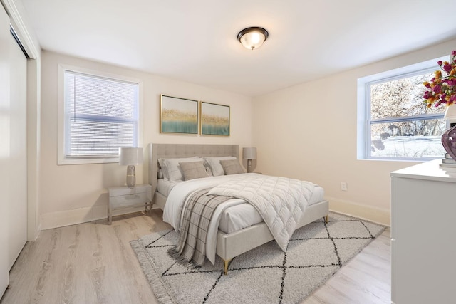 bedroom featuring baseboards and light wood finished floors