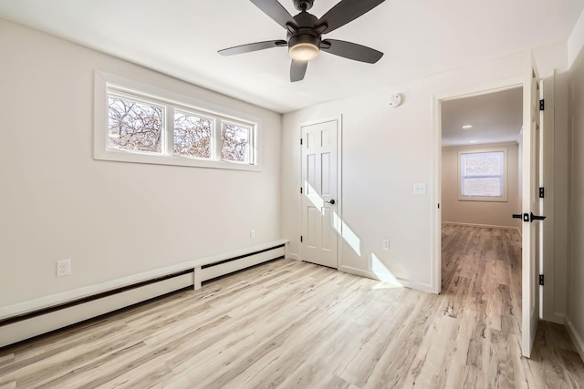 unfurnished room featuring baseboards, baseboard heating, a ceiling fan, and light wood-style floors