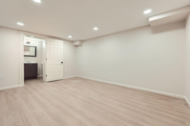 finished basement featuring recessed lighting, light wood-style flooring, and baseboards