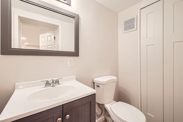 bathroom with toilet, visible vents, and vanity