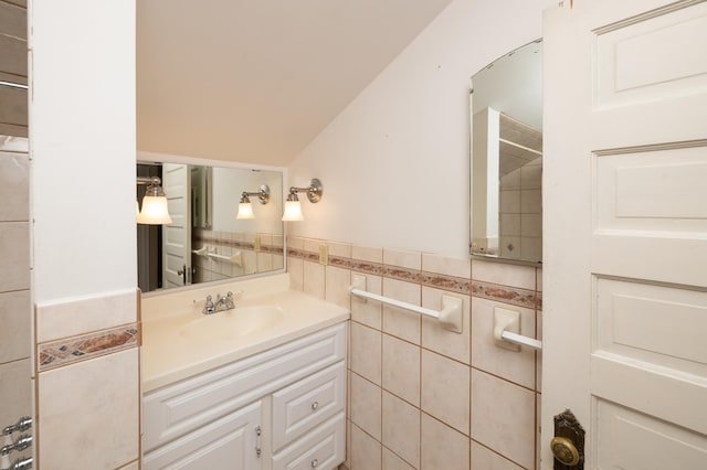 bathroom with a wainscoted wall, tile walls, and vanity