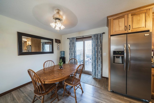 dining space featuring dark wood finished floors, a textured ceiling, baseboards, and ceiling fan