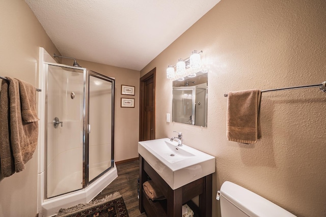 full bath with vanity, a stall shower, wood finished floors, and toilet