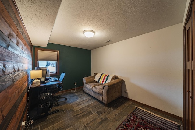 office featuring a textured ceiling, dark wood-type flooring, visible vents, and baseboards