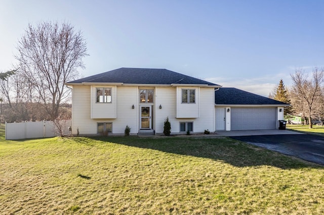bi-level home with fence, a front yard, driveway, and a garage