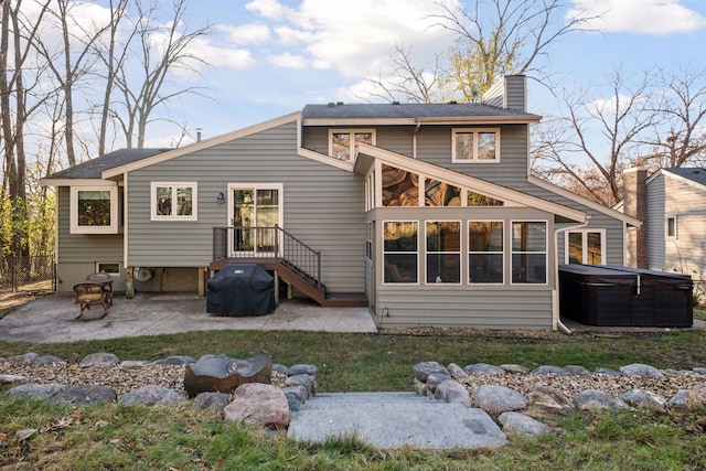 rear view of property with a patio, fence, a chimney, and a hot tub