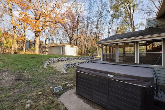 view of yard with an outbuilding, fence, a sunroom, and a hot tub