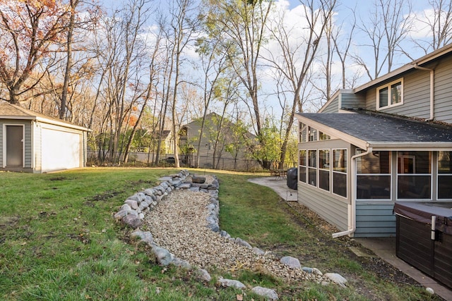 view of yard with an outbuilding, fence, a sunroom, and a patio area