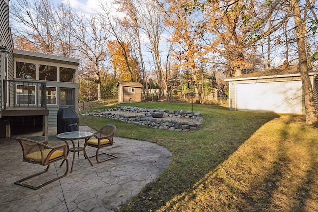 view of yard featuring fence, an outdoor structure, a sunroom, a patio area, and a storage unit