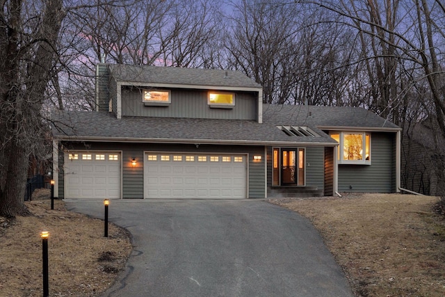 view of front of home with aphalt driveway and roof with shingles