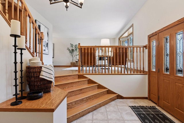 entrance foyer featuring stairs, light tile patterned flooring, and baseboards