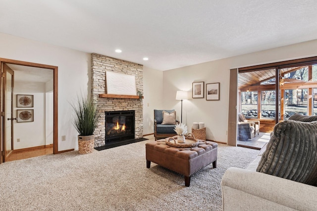 living room featuring a stone fireplace, recessed lighting, baseboards, and carpet