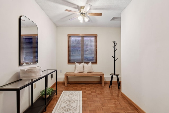 corridor featuring a textured ceiling and baseboards