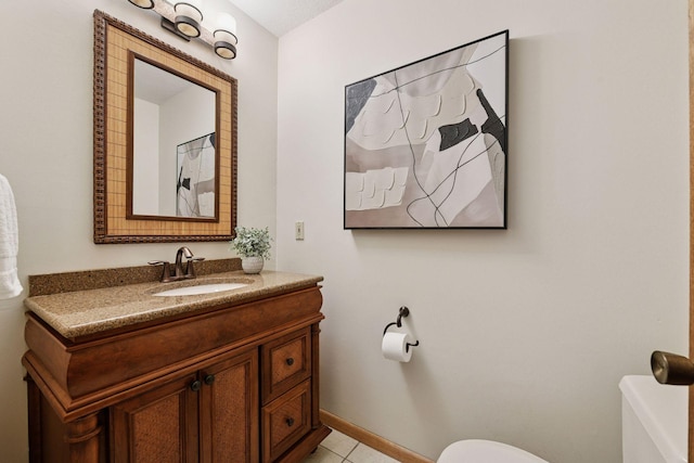 bathroom featuring tile patterned flooring, toilet, vanity, and baseboards